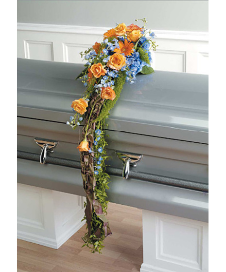 Casket scarf spray comes with blue hydrangea, orange gerbera, orange roses and light blue delphinium with smilax and fern stems. 