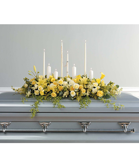 magnificent casket spray has yellow stock, calla lilies, asiatic lilies, roses, alstroemeria, solidago, cream carnations, hypericum ,  4 pillar&taper candles, rosary, salal