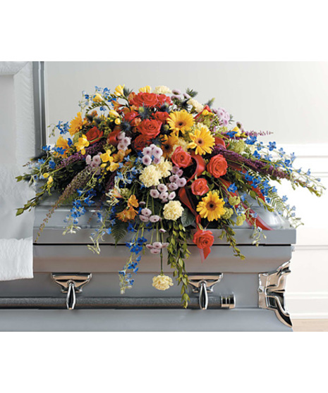 casket spray has delphinium, yellow gerbera, carnations, freesia or spray roses, orange roses, alstroemeria, lavender poms, heather, vibrunum, eryngium, fern, myrtle