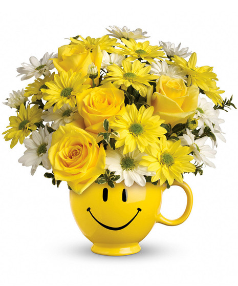 Yellow roses, spray roses and daisy spray chrysanthemums along with white daisy spray chrysanthemums and oregonia are delivered in the one and only Be Happy® mug. 