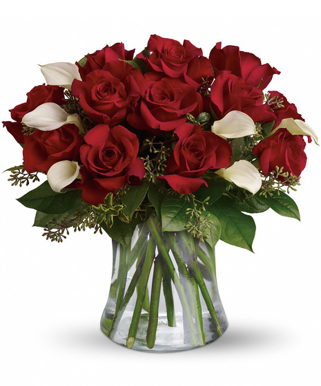 red roses and white calla lilies with salal and seeded eucalyptus in a gathering vase