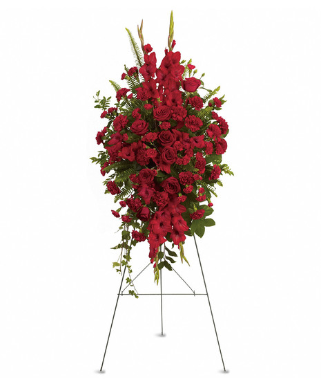 standing spray on green metal easel with red carnations, roses, gladiola with salal, fern, emerald