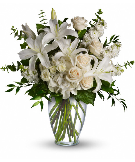 Clear vase with white lilies,roses, spray roses, hydrangea, stock, and greens to includesalal, eucalyptus and ruscus.