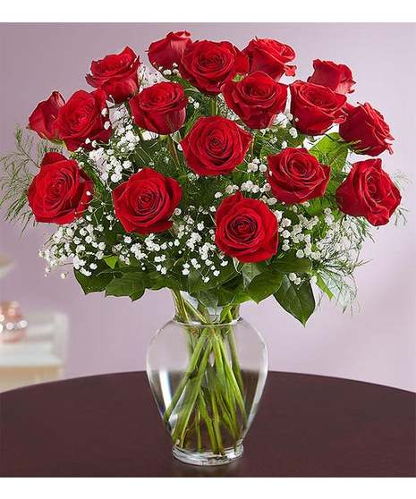 red roses with baby's breath, leather leaf, salal in clear glass vase all round display