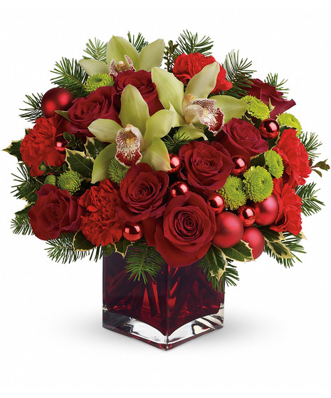 red cube filled with green buttons, red roses, red carnatins, green cymbidiums, and assorted evergreens and red mm balls accents