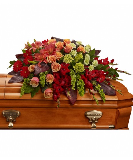 Casket Spray with green hydrangea, orange roses, dark orange asiatic lilies, red gerberas, red gladioli, green carnations and bells of Ireland, with assorted greenery. 