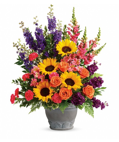 resin planter with sunflowers, orange roses, purple larkspur & delphinium, pink carnations and alstroemeria, leather leaf, salal, emerald one sided