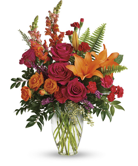 vase with orange lilies, spray roses and snaps and hot pink rose, spray roses, heather, ruscus and eucalyptus