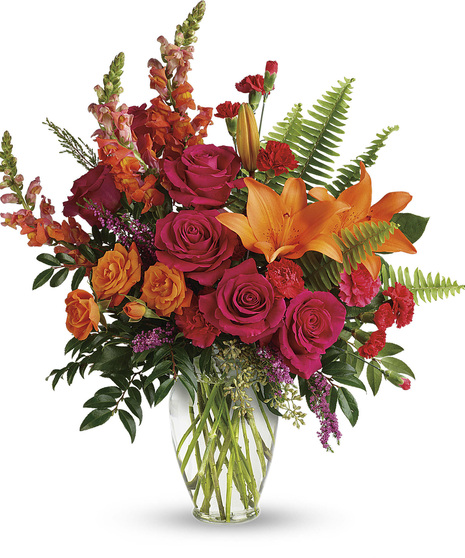 vase with orange lilies, spray roses and snaps and hot pink rose, spray roses, heather, ruscus and eucalyptus