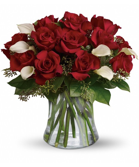 red roses and white calla lilies with salal and seeded eucalyptus in a gathering vase