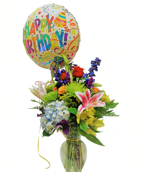 roses, fuji mums, hydrangeas, mini-callas, alstromerias, lilies mixed in bold tones of yellow, red, orange and purple. with 1 bday balloon