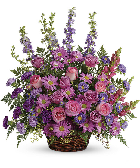 wicker basket wtih lavender roses, larkspur, daisy, carnations, purple carnations and aster, pink roses, snapdragons with seeded eucalyptus, leather leaf ones sided