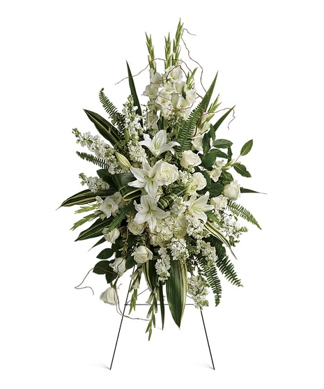 spray includes white hydrangea, white roses, white oriental lilies, white gladioli, white stock, pitta negra, fern, curly willow, variegated aspidistra, salal on a wire easel.