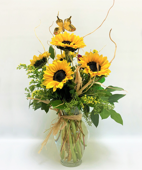 sunflowers come arranged in clear glass vase with salal, leather leaf, curly willow , eucalyptus, solidago and butterfly