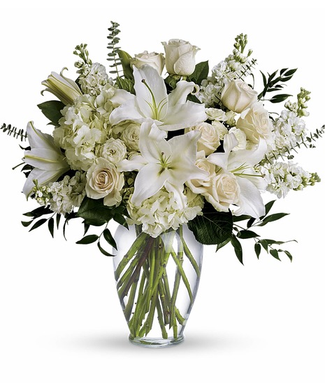 Clear vase with white lilies,roses, spray roses, hydrangea, stock, and greens to includesalal, eucalyptus and ruscus.