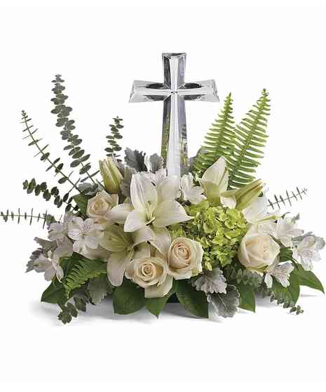 crystal cross at center with white roses, spray roses, lilies, alstromeria nestled in eucalyptus, salal and leather leaf to make a sympathy piece to cherish
