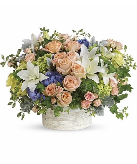 off white ceramic, white lilies, peach roses & spray rose, green hydrangea, roses, dianthus, dusty miller, blue hydrangea, ivy, seed eucalyptus create elegant masterpiece