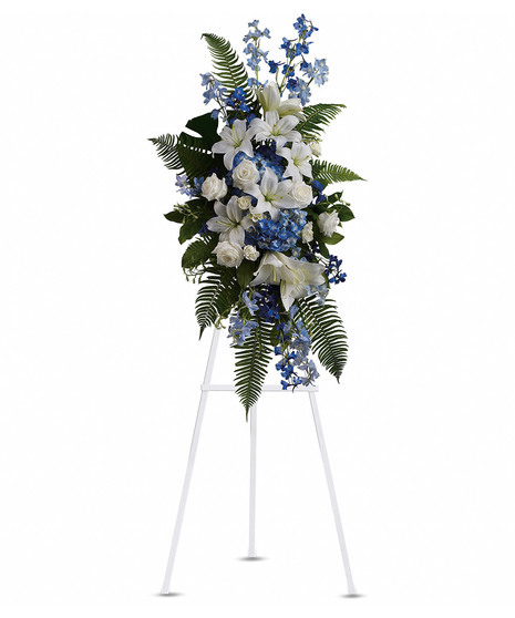 Standing Spray with white roses, white lilies, blue delphinium, blue hydrangeas, white mini carnations, flat fern salal emerald